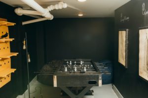 A photo of a communal space in a building in the East Village, NYC including a foosball table.
